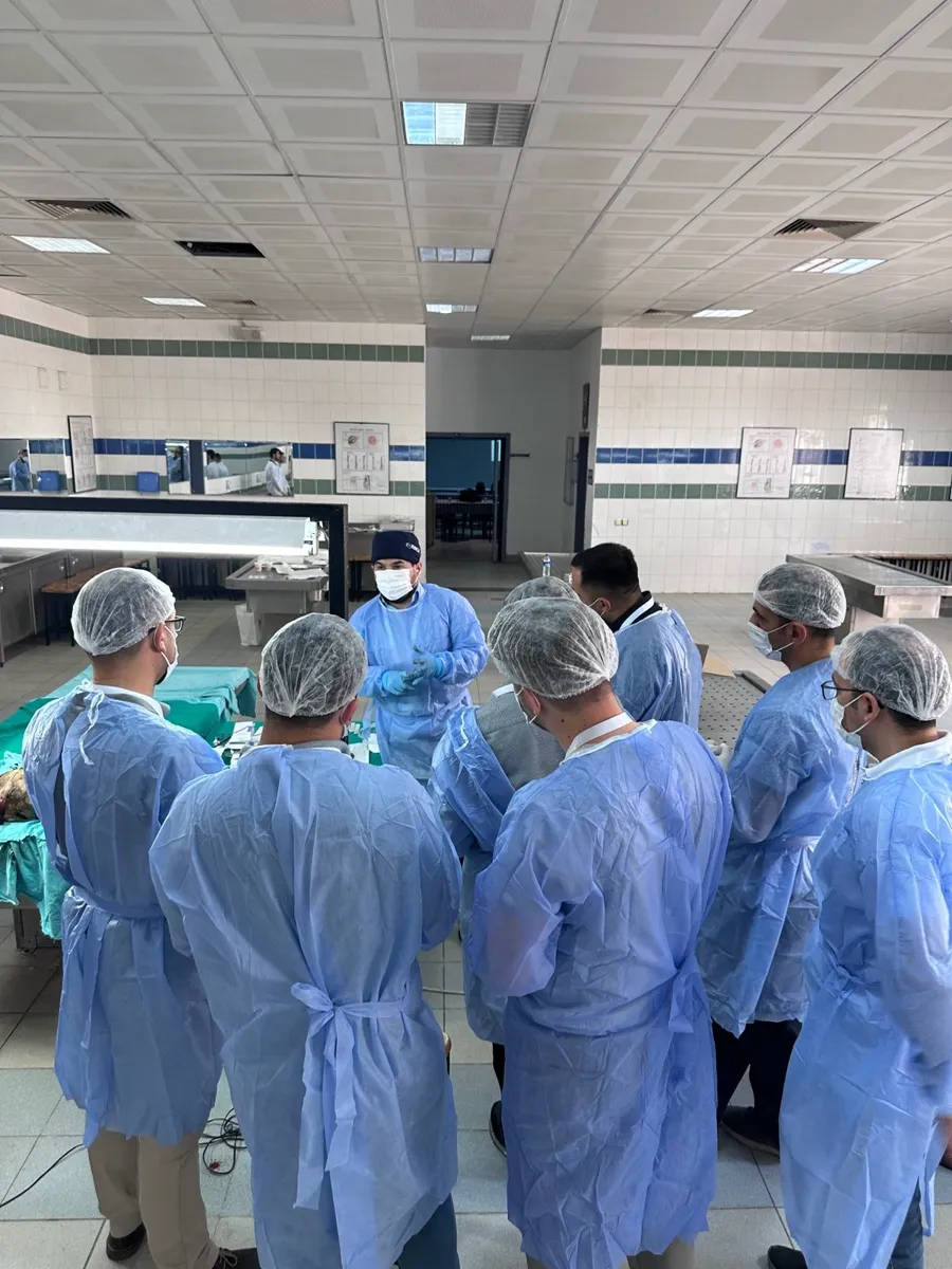 Participants gathered around the instructor in the dissection room at Dr Tas Clinic