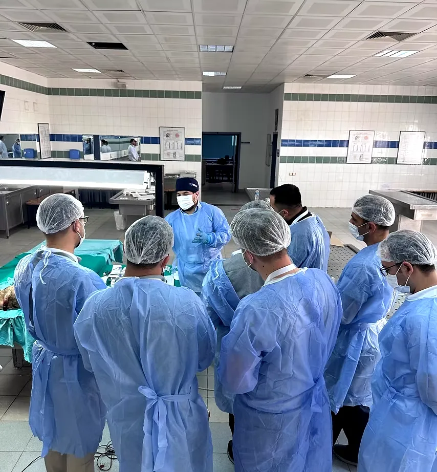 Assoc. Prof. Tuncay Taş briefing course participants around the training table at Dr Tas Clinic